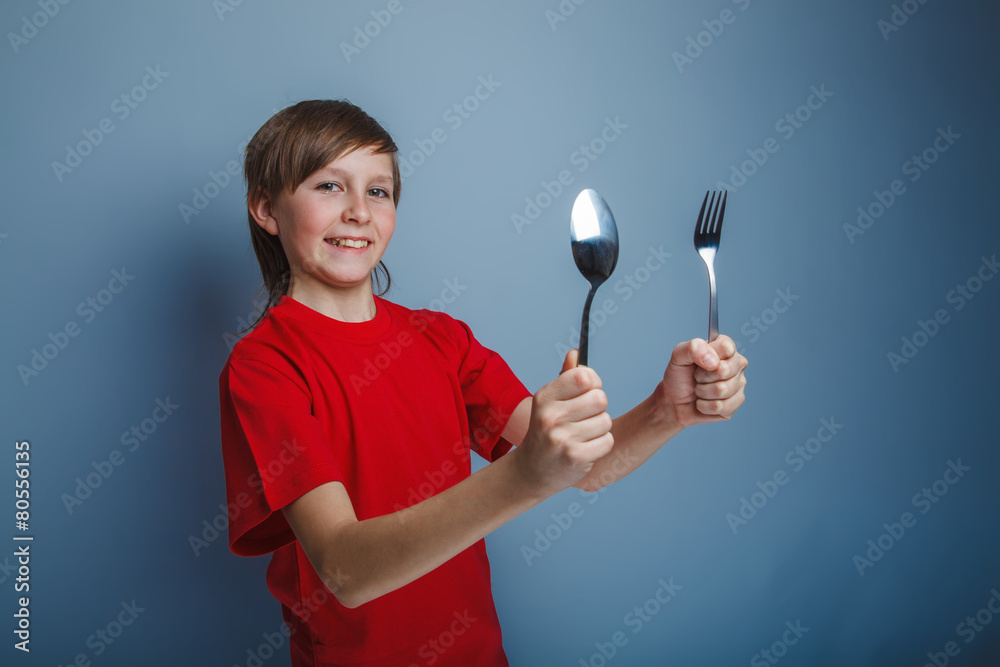 boy teenager European appearance in a red shirt holding a fork a boy teenager European appearance in a red shirt holding a fork a