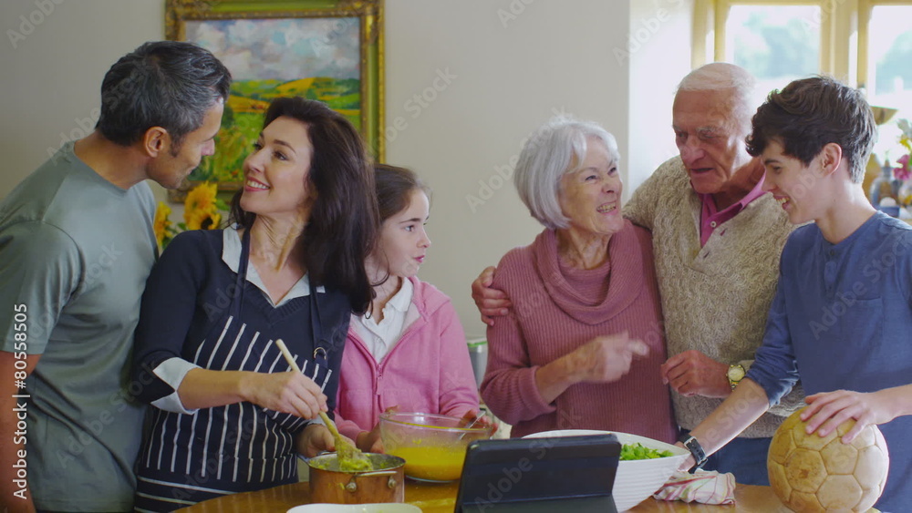 3 generations of happy family preparing a meal together in the kitchen at home