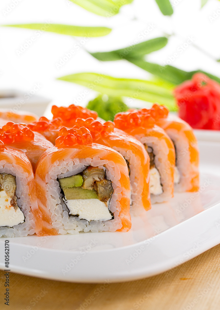 Sushi set on white plate over wooden background Sushi set on white plate over wooden background