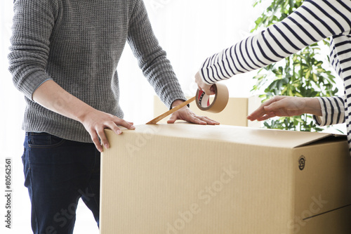 Young couple is closed tape the cardboard box photo