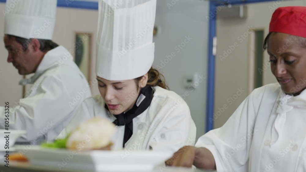 Happy team of chefs in a commercial kitchen, working and chatting together Happy team of chefs in a commercial kitchen, working and chatting together