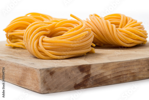 Fototapeta Naklejka Na Ścianę i Meble -  Spaghetti di pasta fresca all’uovo arrotolati su tagliere di leg