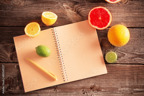 citrus with notebook on old wooden table