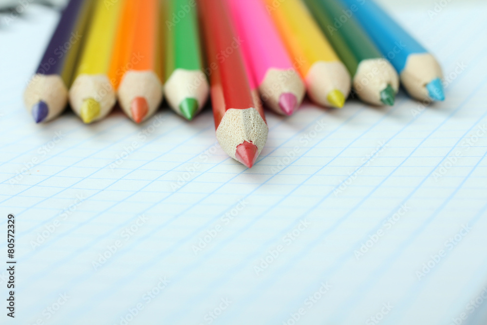 colored pencils on a notebook into a cell colored pencils on a notebook into a cell