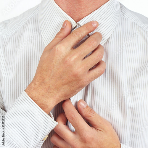 Man straighten collar of his bright shirt close up © Boris Bulychev