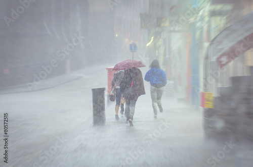 Group of girls walking at summer rain in the city