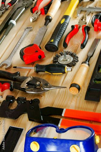 Many working tools on a wooden background.