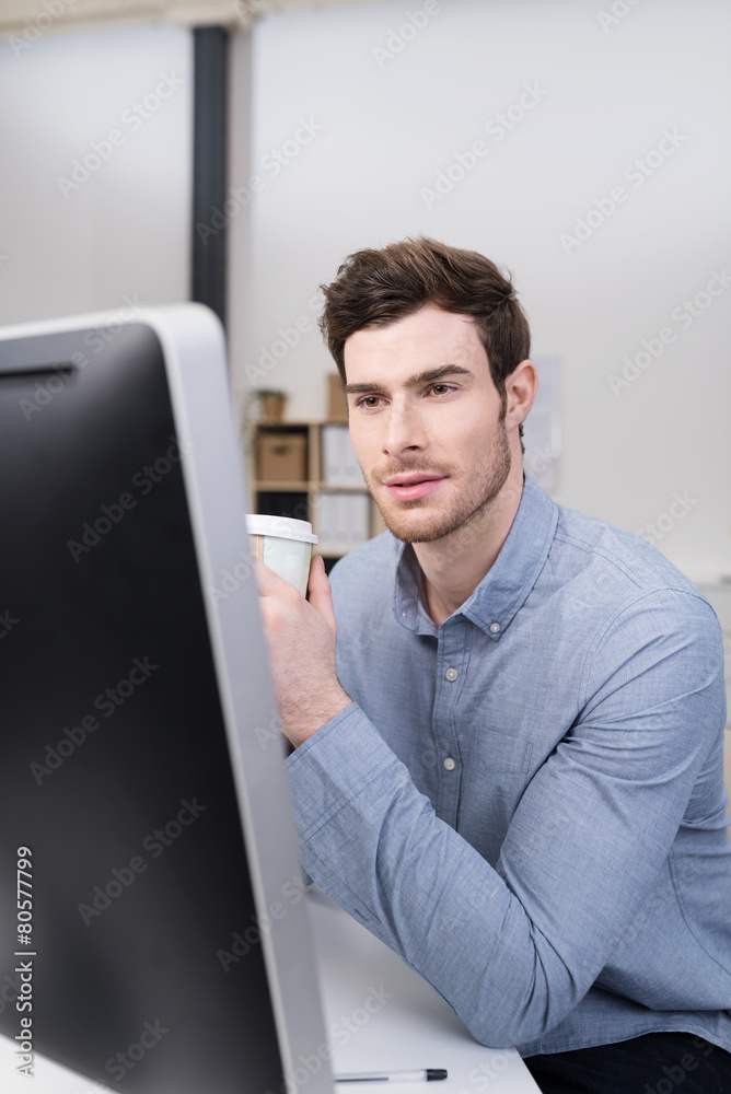 mitarbeiter sitzt am schreibtisch und schaut auf computer mitarbeiter sitzt am schreibtisch und schaut auf computer