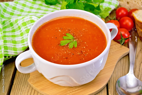 Soup tomato in bowl with spoon on board