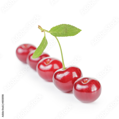 ripe cherries in a row one with stem and leaf isolated