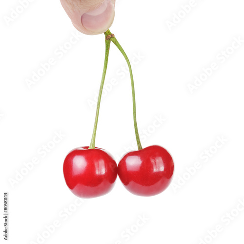 hand holding the two fresh cherries isolated on white
