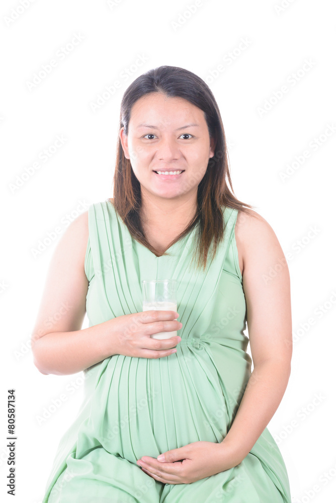 Pregnant Woman holding her pregnant belly and get a glass of mil Pregnant Woman holding her pregnant belly and get a glass of mil