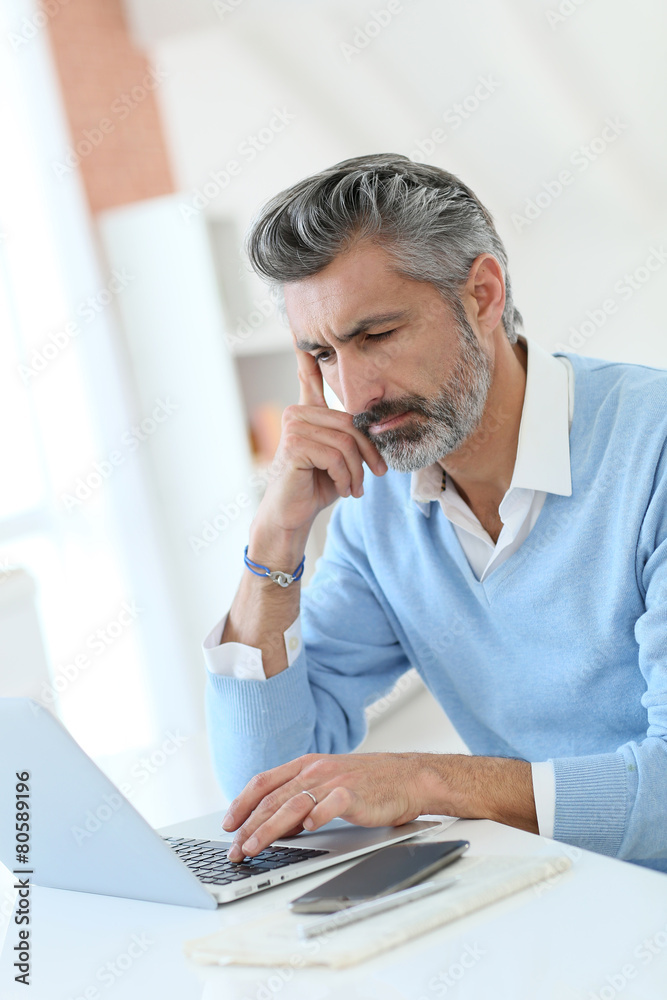 Trendy mature man working from home with laptop Trendy mature man working from home with laptop
