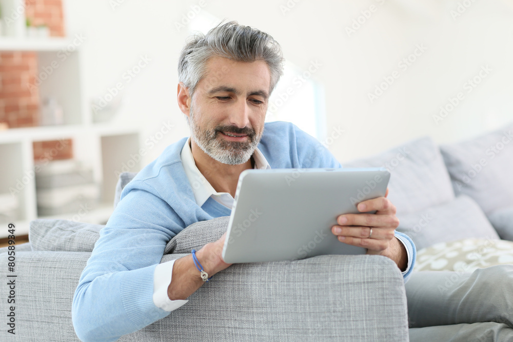 Mature man sending email with digital tablet Mature man sending email with digital tablet