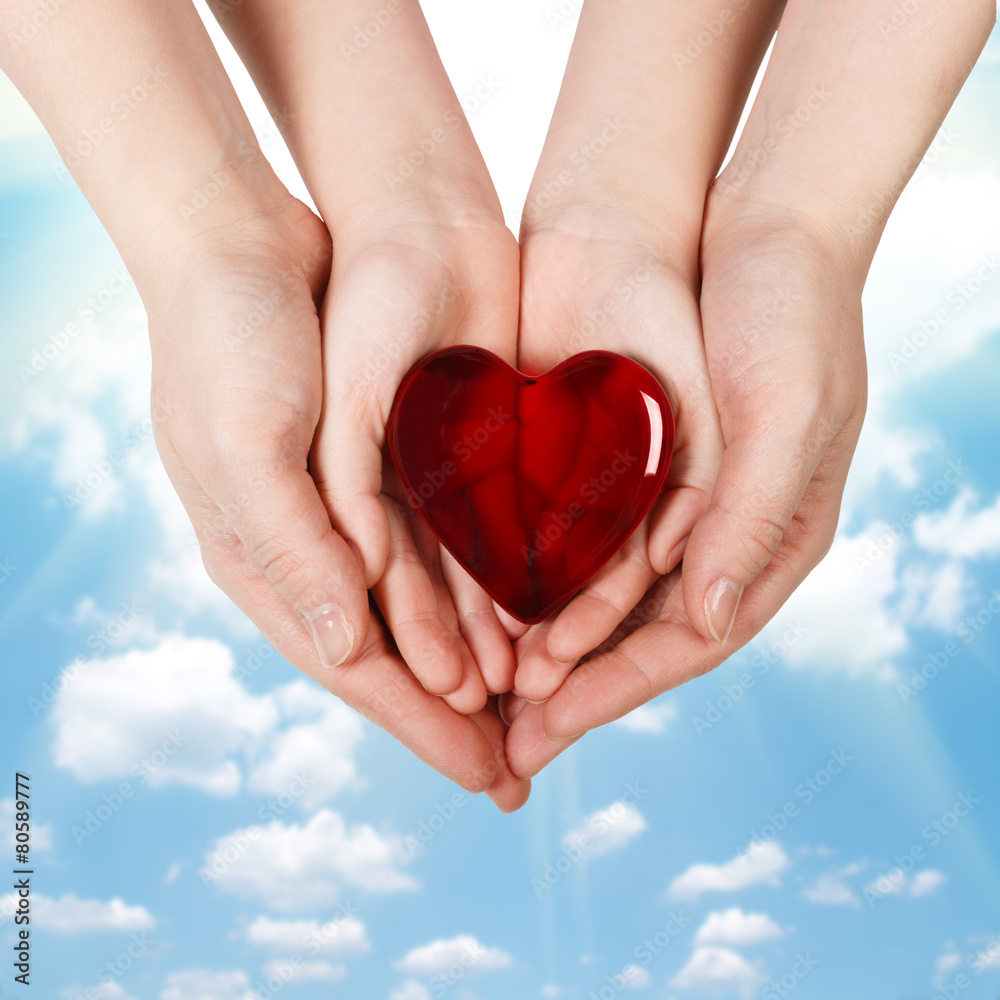 Fototapeta premium Family concept - mother's hands holding child hands with heart