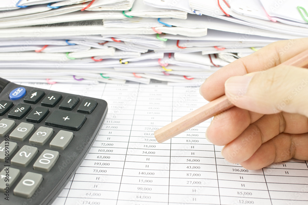 Man is holding bottom of pencil on finance report Man is holding bottom of pencil on finance report