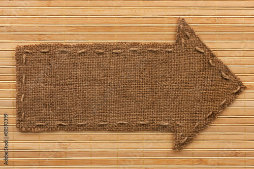Arrow made of burlap lies on a bamboo mat