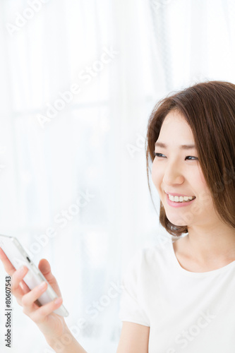部屋でスマホを見る女性 Free Download 部屋でスマホを見る女性 - GFXLoad
