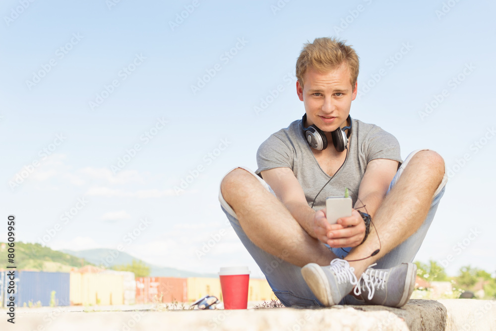 Trendy young millennial man with smart phone and headphones