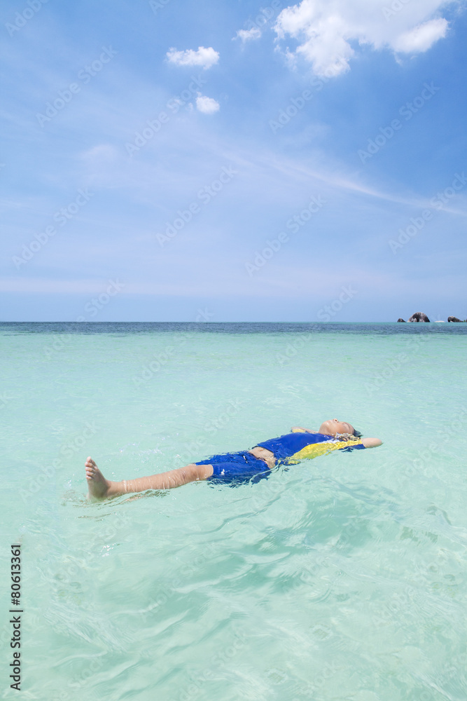 Little boy floating on the beach