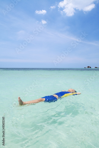 Little boy floating on the beach