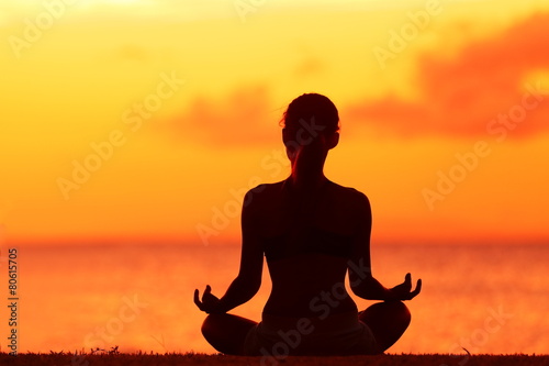 Wellness woman doing zen yoga meditation on beach © Maridav