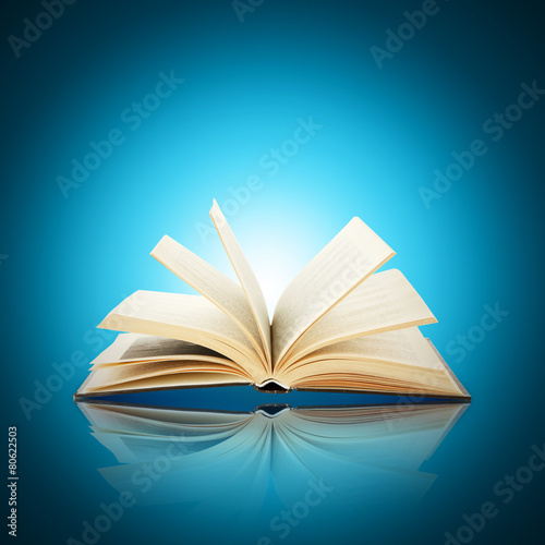 Opened book on bright blue background © Africa Studio