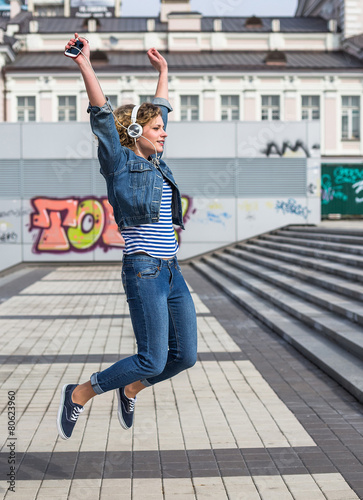 Hipster curly woman enjoy the music in the city © lkoimages