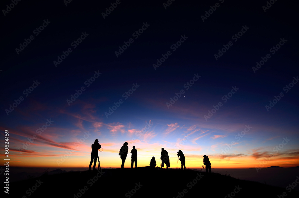 Silhouette of Hiker and Photographer with colorful sunrise Silhouette of Hiker and Photographer with colorful sunrise