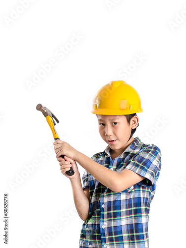 Asian child with yellow helmet and holding hammer with copyspace