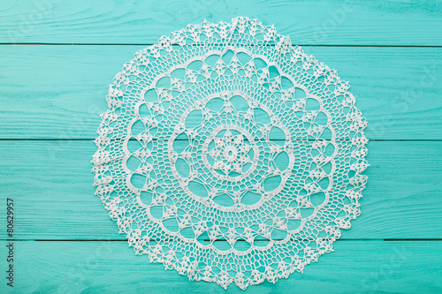Round lace doily on wooden background