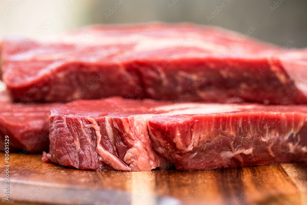 Fresh beef steaks on wooden board