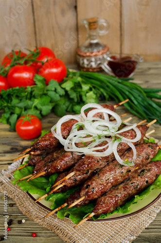 Grilled kebabs on wooden skewers and fresh vegetables
