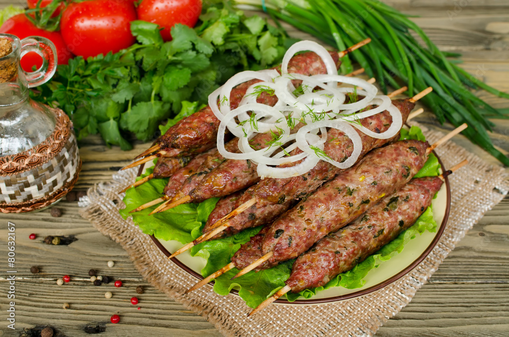 Grilled kebabs on wooden skewers and fresh vegetables Grilled kebabs on wooden skewers and fresh vegetables