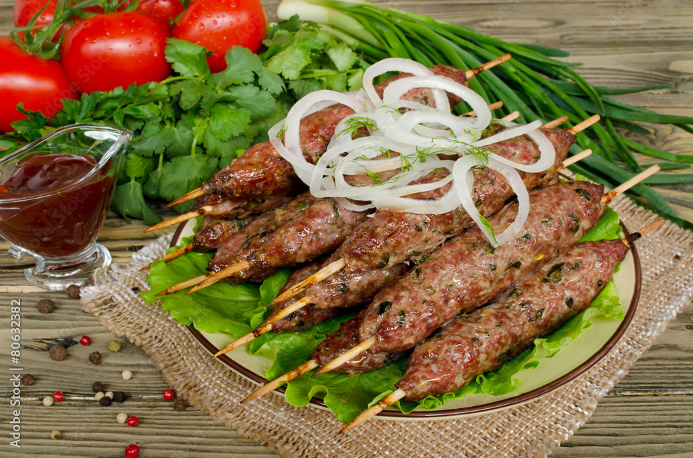 Grilled kebabs on wooden skewers and fresh vegetables Grilled kebabs on wooden skewers and fresh vegetables
