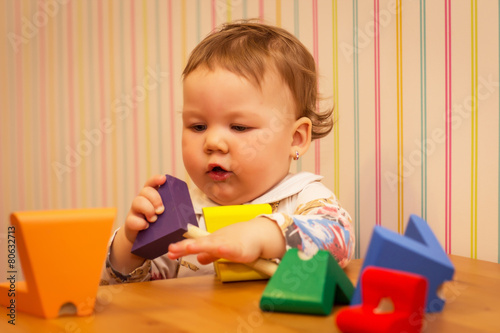 little girl playing with wooden toys, wooden tree