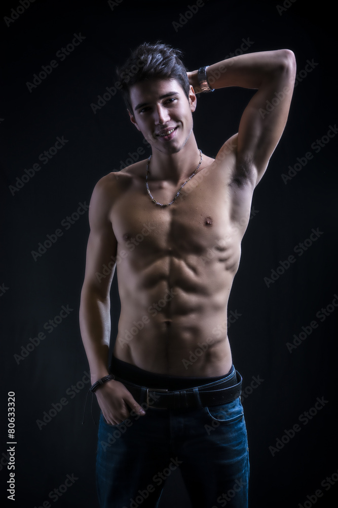 Handsome muscular shirtless young man standing smiling c Handsome muscular shirtless young man standing smiling c
