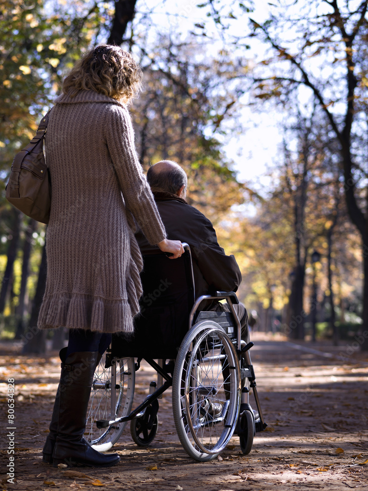 Woman pushing a wheelchair in the park