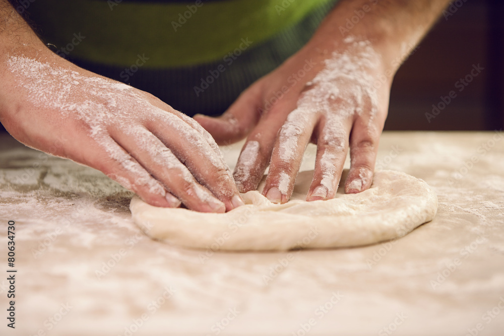 hands knead the dough for pizza making