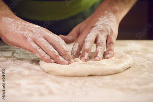 hands knead the dough for pizza making