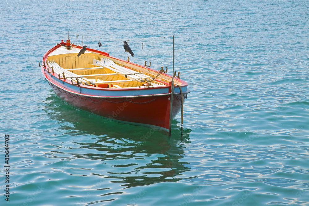 Wooden red boat in a calm lake
