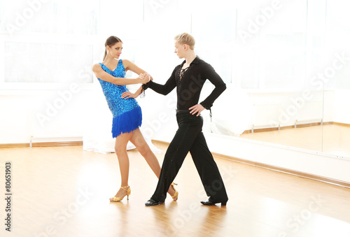 Beautiful couple in active ballroom dance, indoors
