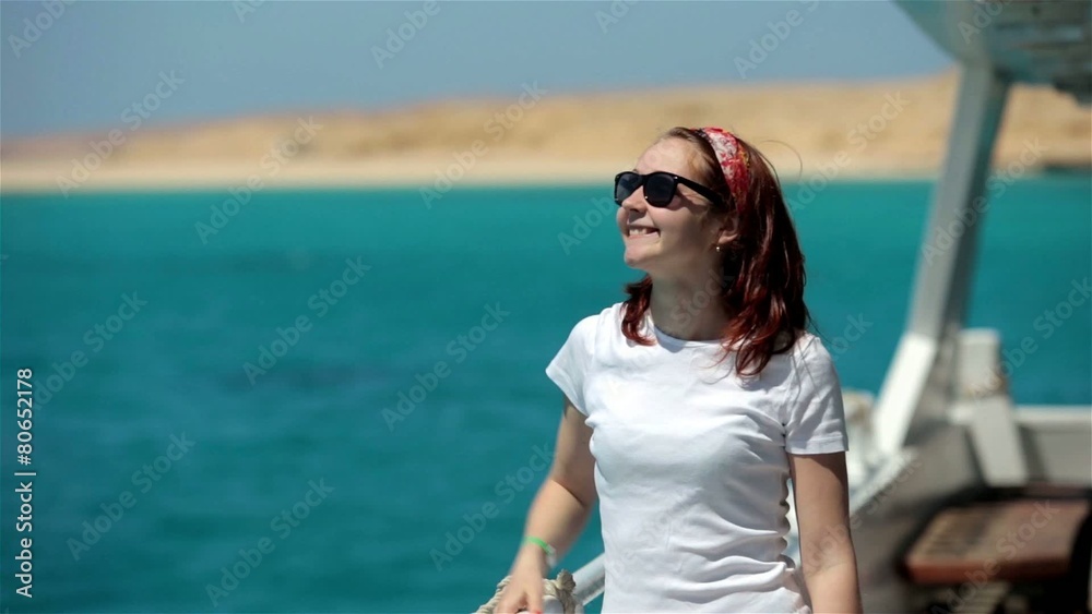 Young happy of life woman in sunglasses walking on deck of boat Young happy of life woman in sunglasses walking on deck of boat