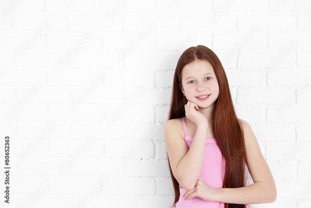 Beautiful little girl on bricks wall background Beautiful little girl on bricks wall background