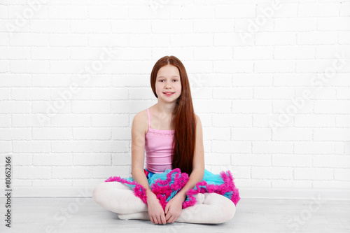 Beautiful little girl on  white bricks wall background photo