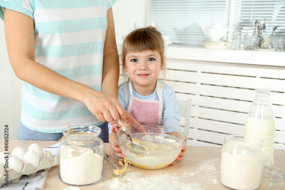 Little girl preparing cookies with mother in kitchen at home Little girl preparing cookies with mother in kitchen at home