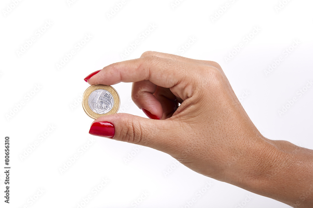 Woman's hand holding a Brazilian coin Woman's hand holding a Brazilian coin