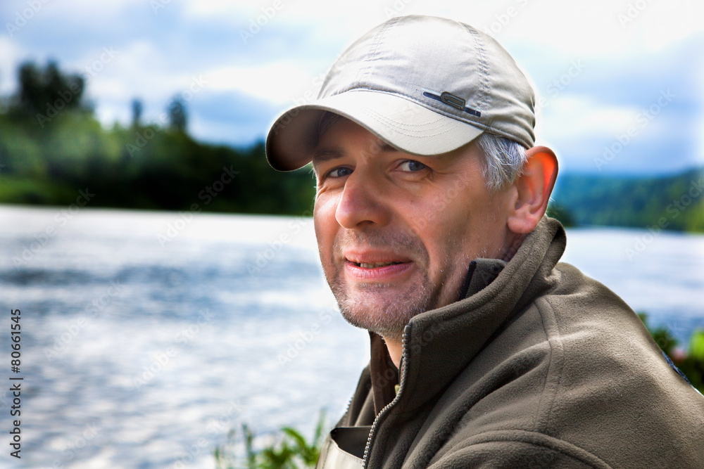 Portrait of a fisherman on a background of the river Portrait of a fisherman on a background of the river
