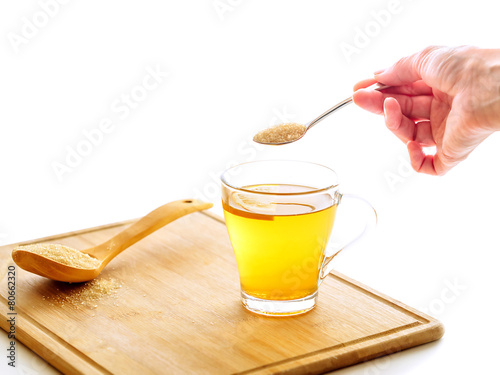 Hand holding teaspoon full of sugar