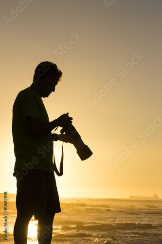 Photographer reviewing his images at sunset
